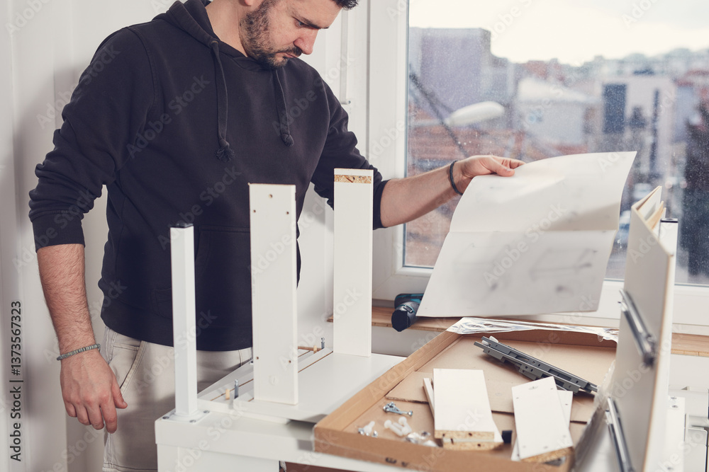 Man working and assembling furniture in a new apartment.