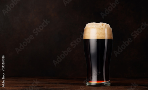 Foto A glass of stout beer with a frothy head