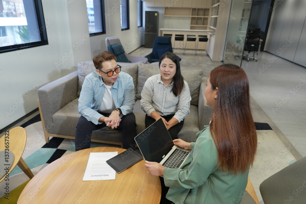 Asian female salesperson presenting business to investors. Asian male and female presenting insurance plans with laptop in office company lounge.