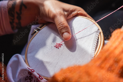 close up of woman hands embroidering using embroidery hoop and sewing kit on canvass. concept of at home craft activity