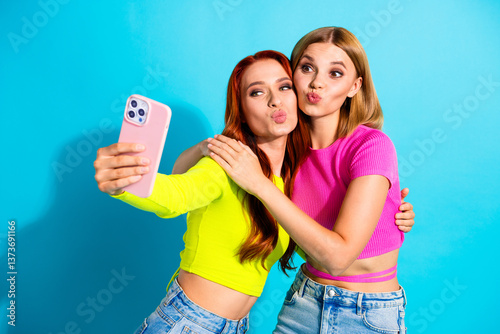 Fotografie Stylish young girlfriends posing with pouting faces for a selfie against a vibra