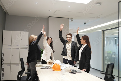 Obraz na płótnie Group of Asian men and women standing together in conference room celebrating successful work, shaking hands
w salonie