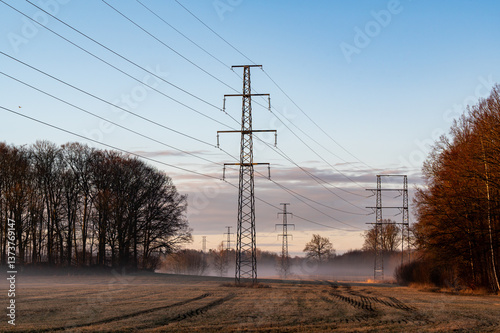 Powerline over field a misty morning in Kumla Sweden