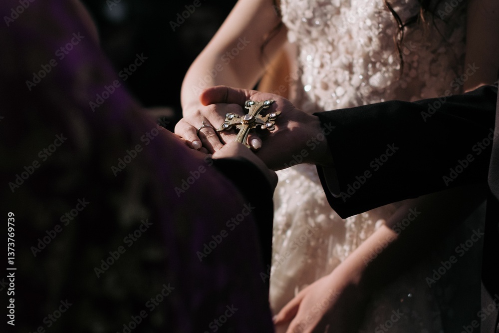 Obraz premium Hands holding a cross during a wedding ceremony.