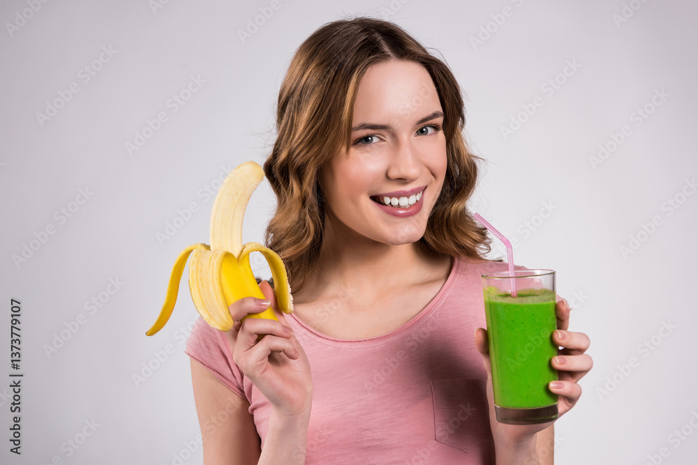 Girl posing with green juice and banana isolated. Girl posing with green juice and banana isolated.