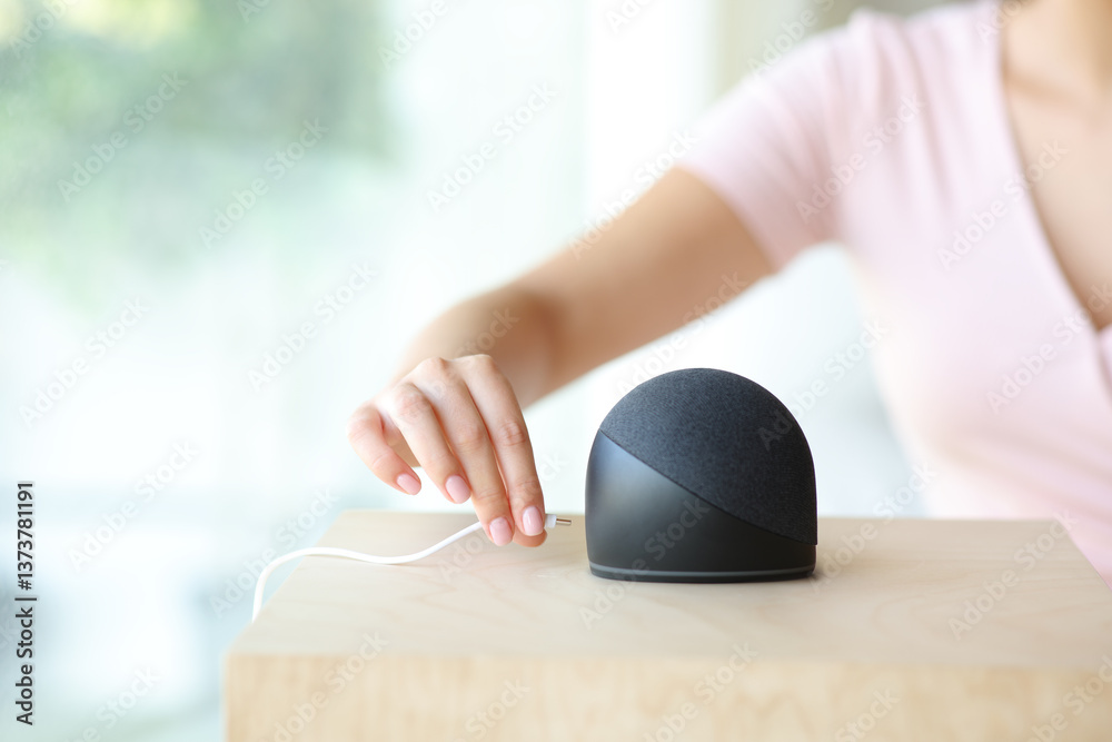 Fototapeta premium Woman hand plugging charger to smart speaker