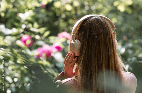 A beautiful 35-year-old woman listens to music with large headphones. Close-up. Harmony, relaxation and relaxation.