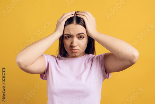 Young, irritated girl grabbing head.
