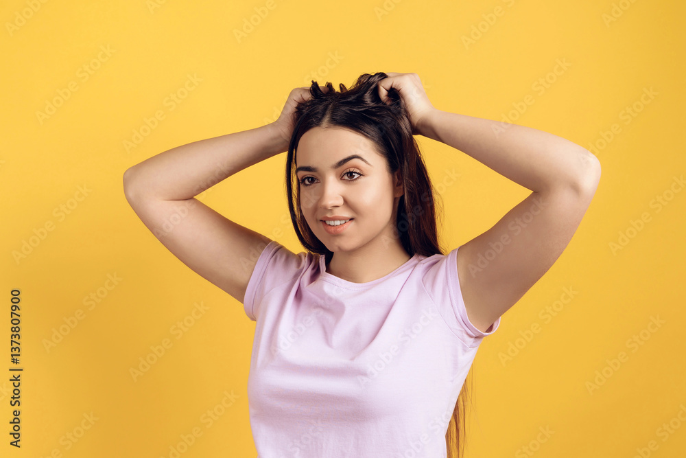 Fototapeta premium Young joyous girl ruffles long hair on head.