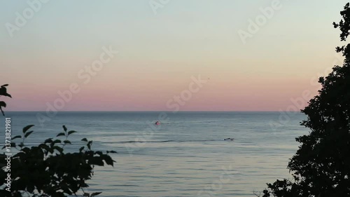 Beautiful, summer, warm sunset on the shores of the Black Sea. Vacation, recreation, tourism. A tourist boat floats in the distance. High quality FullHD footage