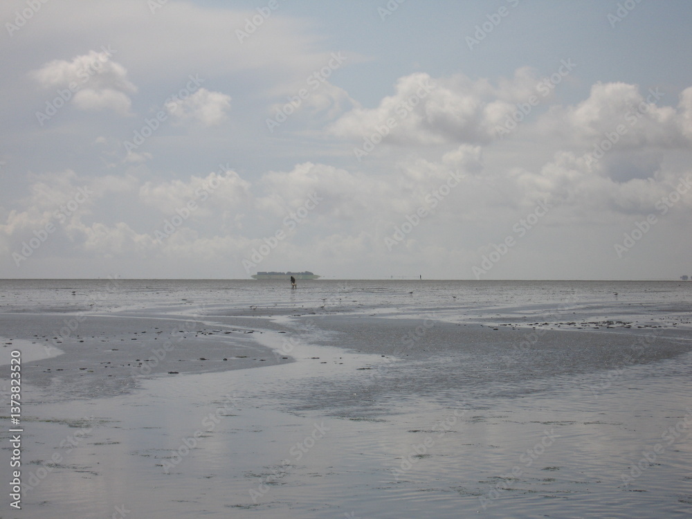 Wolken und Luftspiegelung im Wattenmeer an der Nordsee