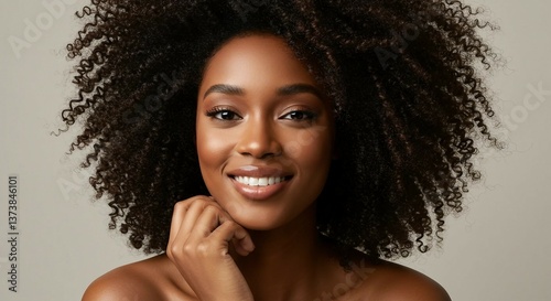 Smiling Afro-American woman with natural curls in soft lighting