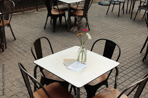 Outdoor Cafe with Rustic Tables and Fresh Flowers in Barcelona Gothic Quarter