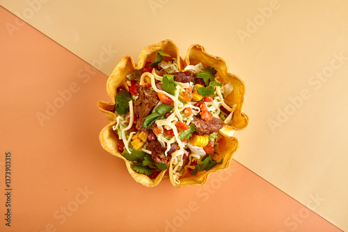 Taco salad in tortilla bowl with beef, cheese, corn and lettuce