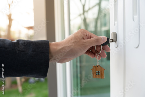 Landlord key for unlocking house is plugged into the door. Second hand house for rent and sale. Owner use hand unlock door mortgage for new home, buy, sell, renovate, investment, owner, estate photo