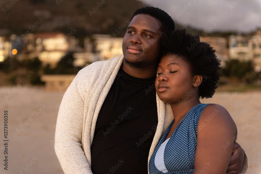 Young African couple looking at the view from a beach at dusk Young African couple looking at the view from a beach at dusk
