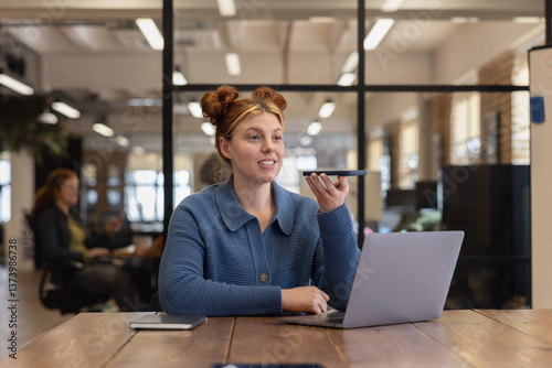 Young businesswoman using voice command for efficient work