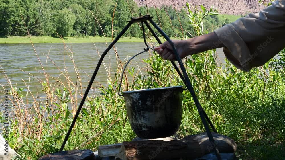 Steaming kettle over open fire symbol of traditional outdoor meals Warmth of flickering flames and fresh air combine to create a comforting and nostalgic campfire moment Concept of outdoor recreation