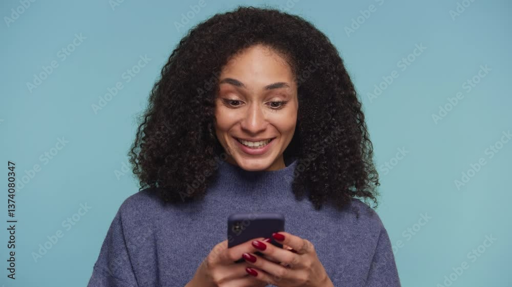 Excited woman reading message on smartphone on blue background Excited woman reading message on smartphone on blue background