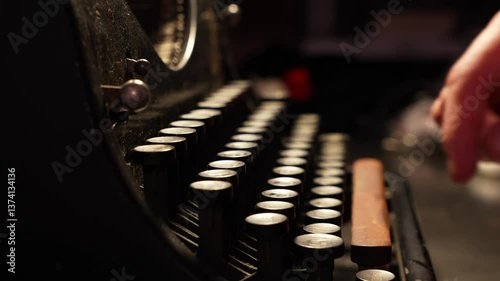 Close-up of a person's hand typing on an old vintage typewriter.