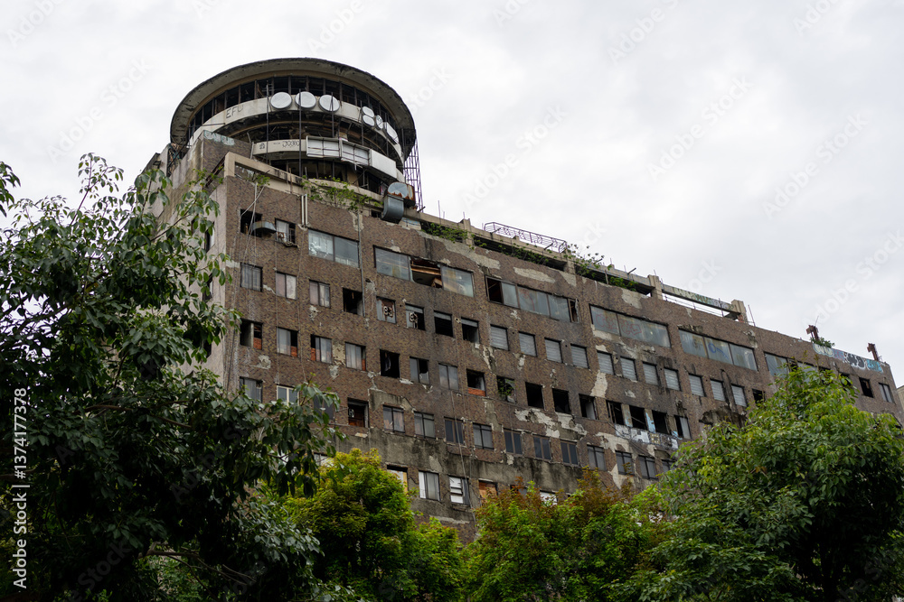 An exterior of the derelict Hotel Continental in Cali, Colombia, with a cloudy sky backdrop.