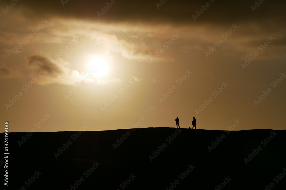 People watching a colorful sunset at a Maspalomas dune, Gran Canaria island