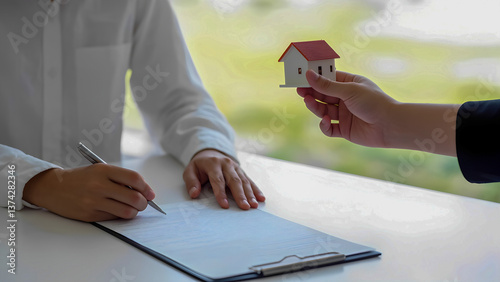 Real estate transaction with house model between business professionals at office
