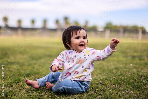 Little girl playing with bubbles in garden, nice day and funny