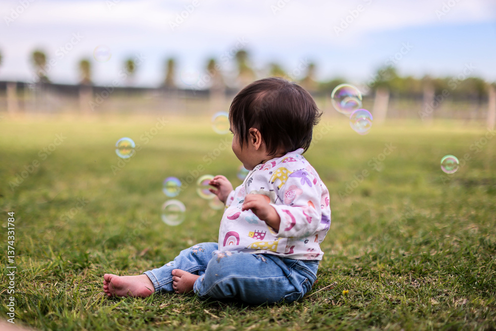 Little girl playing with bubbles in garden, nice day and funny Little girl playing with bubbles in garden, nice day and funny