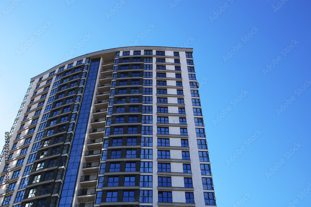 A tall building stands out against a clear, bright blue sky A tall building stands out against a clear, bright blue sky