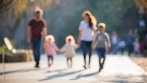 A blurred image of a family walking in the park, with children holding hands