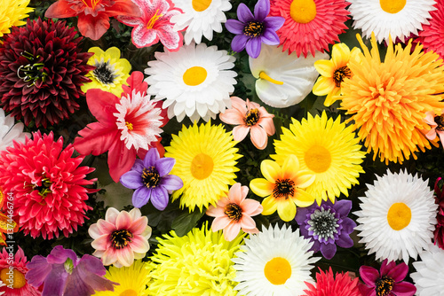 Bild auf Leinwand Colorful artificial flowers in garden, top view, floral background