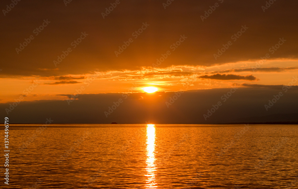 Sunset over Lake Leman with golden skyline and reflective water Sunset over Lake Leman with golden skyline and reflective water