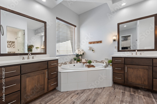 A spacious bathroom featuring two sinks, a bathtub, and two mirrors