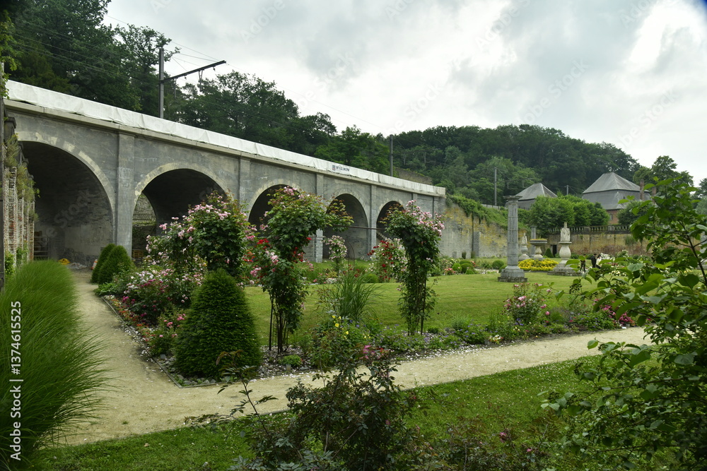 Fototapeta premium Jardin passant sous les arches du viaduc du chemin de fer à l'abbaye de Villers-la-Ville en Brabant Wallon 