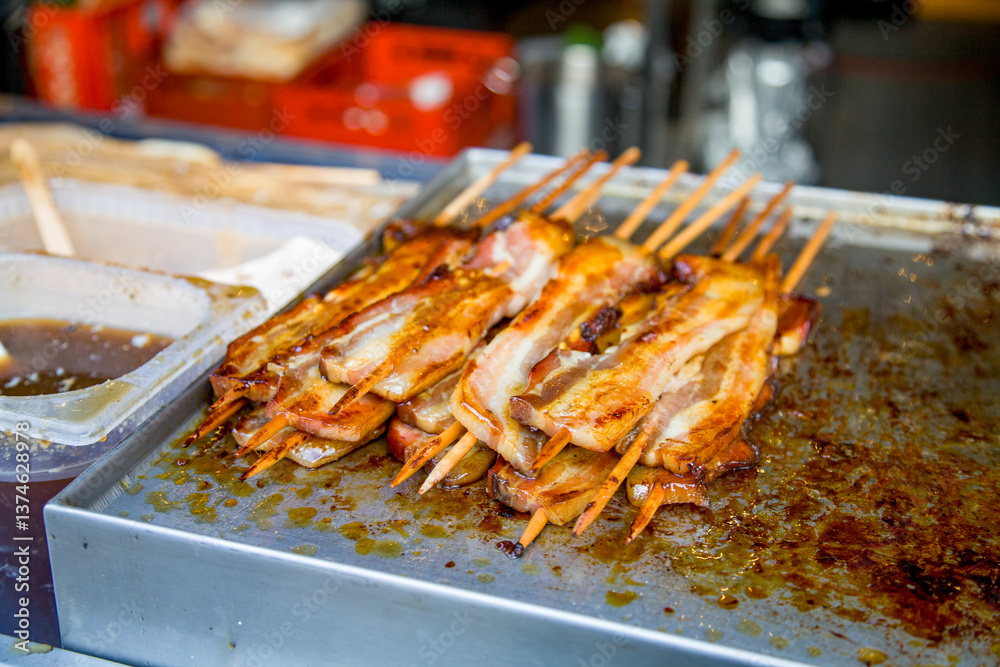 Street food, a hearty bacon kebab with sauce, grilled on a barbecue Street food, a hearty bacon kebab with sauce, grilled on a barbecue