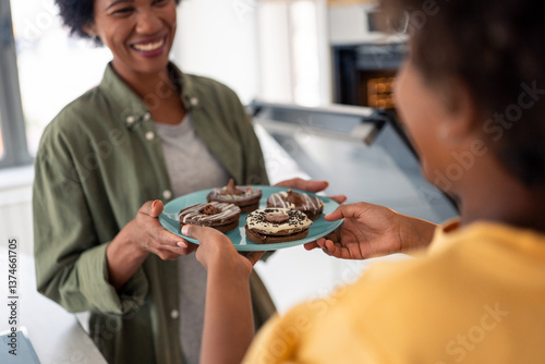 Cheerful African American Mother And Child Sharing Chocolate Cookies In Bright Modern Kitchen