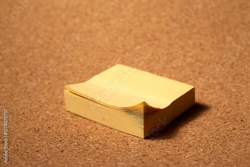 Yellow sticky notes clustering on cork board, highlighting organizational strategy with workspace communication tool for capturing ideas and important reminders