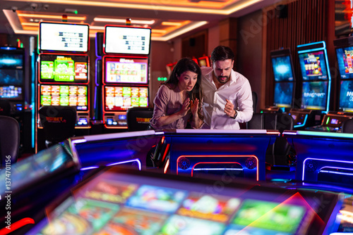 Excited Couple Plays Slot Machines in a Vibrant Casino Environment