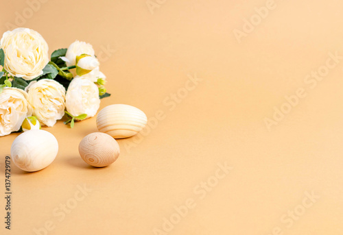 Traditional Easter wooden eggs, bouquet of delicate flowers and on beige background with text space