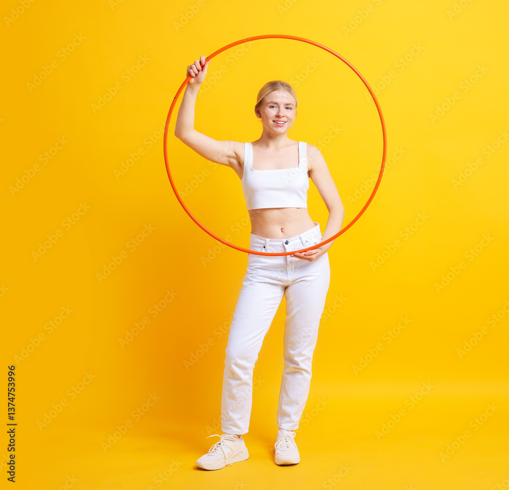 Beautiful young woman with hula hoop on yellow background Beautiful young woman with hula hoop on yellow background