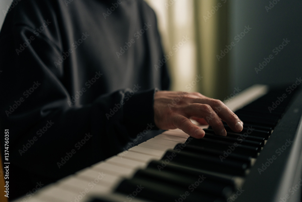 Obraz premium Close-up view of musician hands skillfully playing synthesizer in cozy home studio, crafting melodies and enjoying creative process in personal and inviting space. Concept of recording music at home.