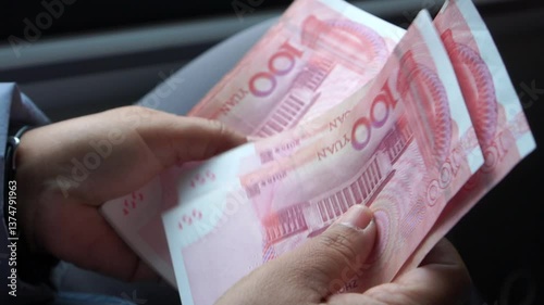 Chian yuan cash money one hundred Chinese yuan bills, yuan banknotes Chinese currency (Renminbi or RMB) featuring 100-yuan banknote with Mao Zedong's for goods services, Cash on car