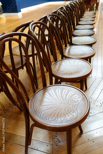 Rows of wooden chairs in an art gallery.