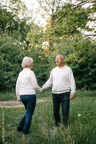 28.09.24 Vinnitsa, Ukraine: a nice couple of grandparents who look good and pose for a photo in light clothes in front of a park