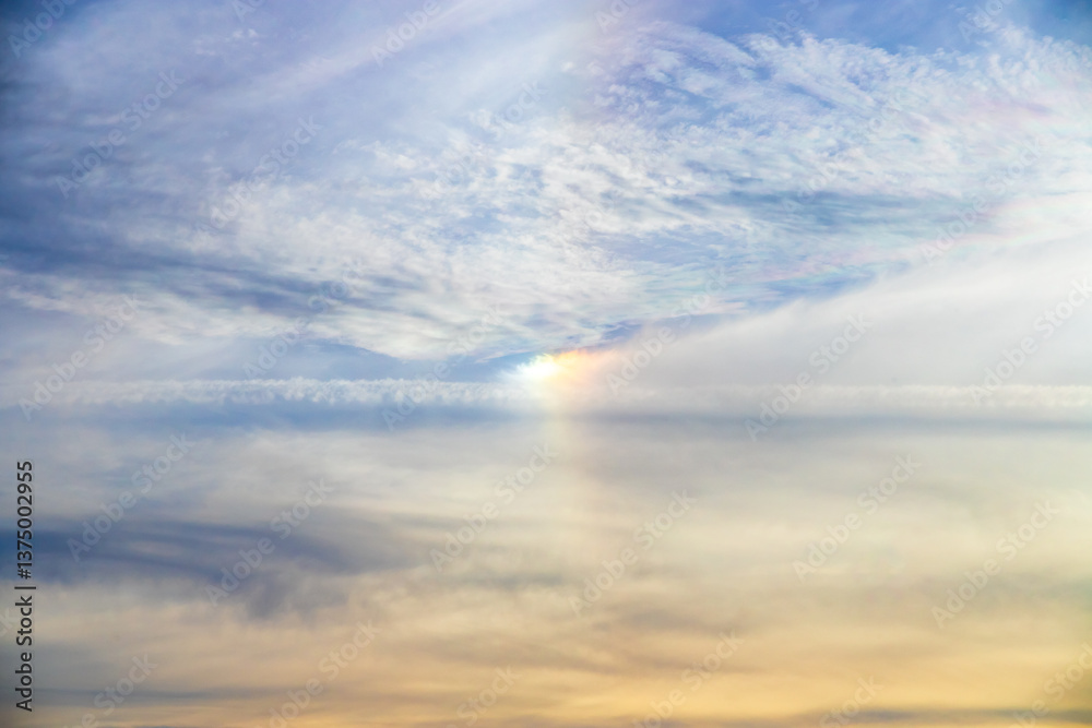 Fototapeta premium Optical effect of colored lights between the clouds of a blue sky