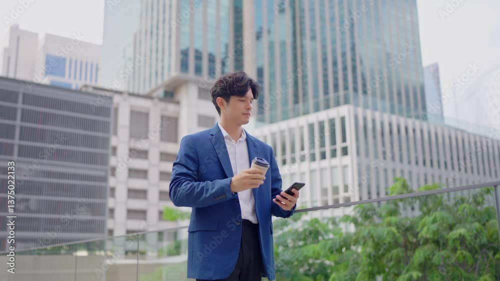 Asian young businessman chatting on smartphone while standing in city. Asian young businessman chatting on smartphone while standing in city.