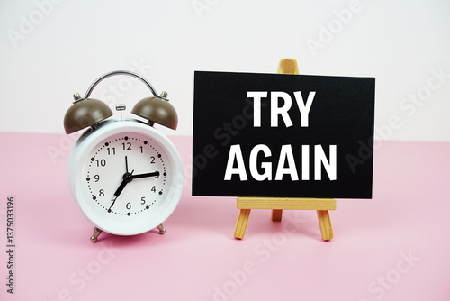 Try Again text on paper card with alarm clock on pink background