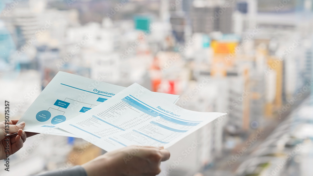 Woman looking at documents with city in the background