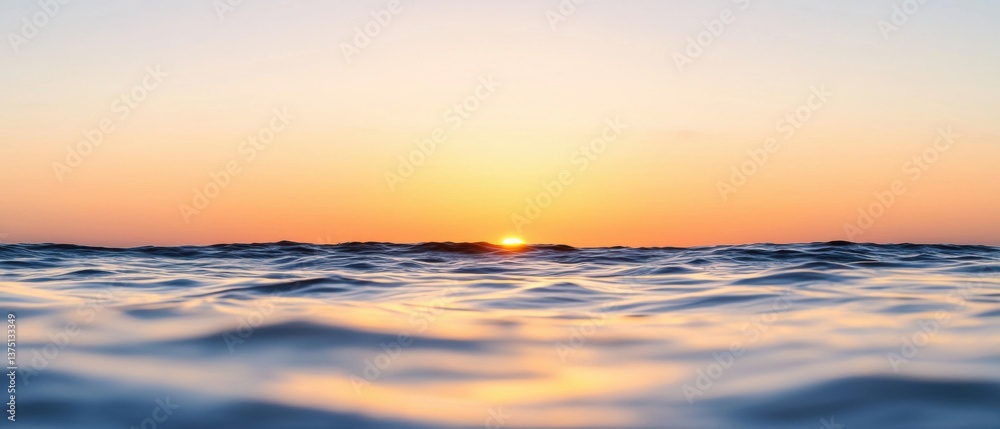 Obraz premium Photograph of a beautiful sunset over the ocean. the sky is a gradient of orange and yellow, with the sun partially visible in the center.